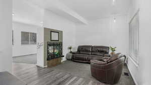 Living area featuring baseboards, wood finished floors, and visible vents