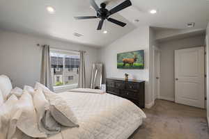 Bedroom with visible vents, carpet flooring, baseboards, and lofted ceiling