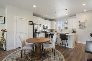 Dining room with recessed lighting, baseboards, and dark wood finished floors