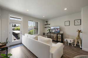 Living room featuring recessed lighting, baseboards, wood finished floors, and a textured ceiling