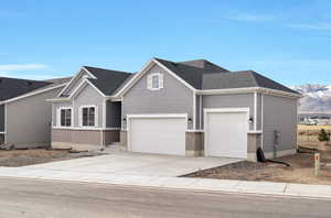 View of front of house featuring a garage, a mountain view, driveway, and brick siding