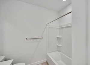 Full bath with baseboards, vanity, toilet, and bathing tub / shower combination