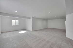 Basement with baseboards, recessed lighting, and light colored carpet