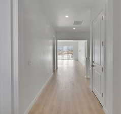 Corridor with visible vents, baseboards, recessed lighting, a textured ceiling, and light wood-style flooring