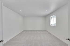 Spare room featuring baseboards, light carpet, and recessed lighting