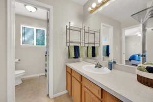 Full bathroom with vanity, baseboards, and separate bathroom, and toilet