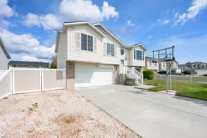 View of front of home featuring fence, driveway, a residential view, and a garage