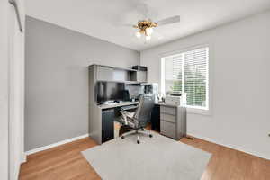 Office area featuring ceiling fan, baseboards, and light wood finished floors