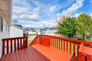 Deck featuring a lawn, a fenced backyard, a playground, and a residential view