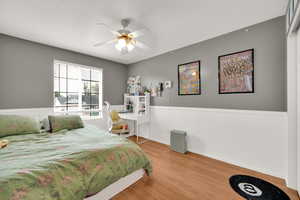 Bedroom with ceiling fan and wood finished floors