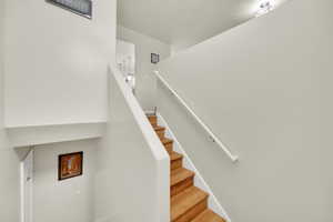 Stairs with baseboards and wood finished floors