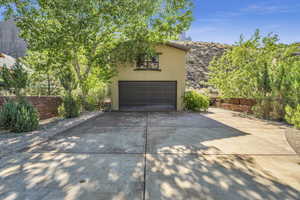 Garage featuring fence and concrete driveway