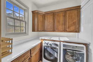 Laundry room with washer and clothes dryer and cabinet space