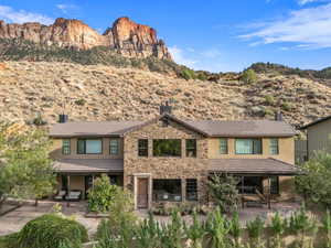 Exterior space with a patio, a mountain view, stucco siding, and a chimney