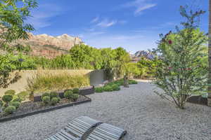 View of yard with fence, a mountain view, and a patio