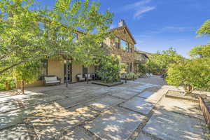 Back of property featuring a chimney, a patio, and stucco siding