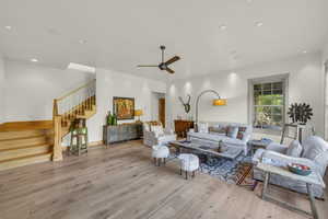 Living area featuring recessed lighting, a ceiling fan, hardwood / wood-style flooring, and stairs