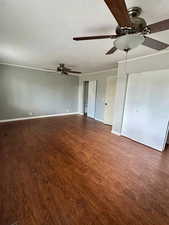 Interior space featuring baseboards, ceiling fan, and dark wood-type flooring