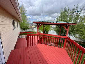 Wooden deck featuring a gazebo and a fenced backyard
