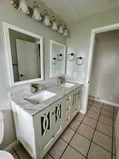 Full bath with a sink, tile patterned floors, double vanity, and visible vents