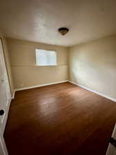 Empty room featuring baseboards and wood finished floors