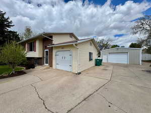 View of side of property featuring a garage and an outbuilding