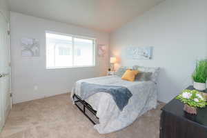 Bedroom featuring baseboards, carpet flooring, and lofted ceiling