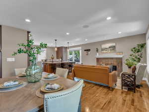 Dining space with a fireplace, recessed lighting, and warm hardwood floors