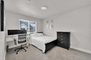 Carpeted bedroom featuring a textured ceiling, baseboards, and visible vents