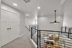 Hall with visible vents, baseboards, recessed lighting, carpet flooring, and an upstairs landing