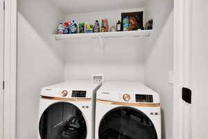 Clothes washing area featuring washing machine and clothes dryer and laundry area