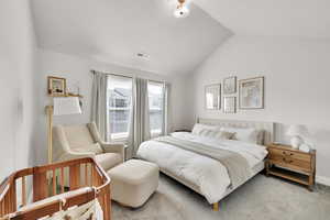 Bedroom with light carpet, lofted ceiling, and visible vents