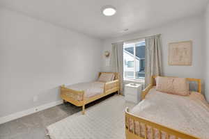 Carpeted bedroom featuring baseboards and visible vents