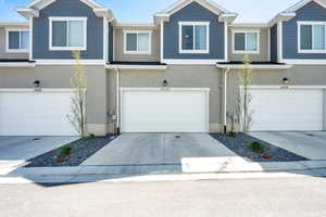 Multi unit property featuring an attached garage, stucco siding, and driveway
