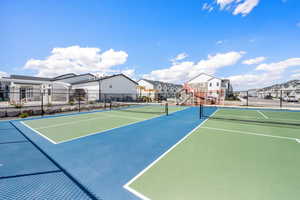 View of tennis court with fence and a residential view