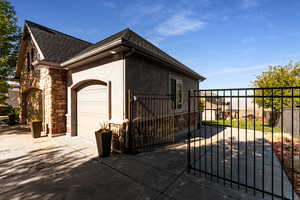 View of home's exterior featuring roof with shingles, fence, an attached garage, and stone siding