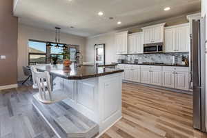 Kitchen featuring a sink, light wood-style floors, crown molding, and stainless steel microwave