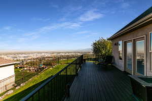 Wooden deck featuring a mountain view and a yard