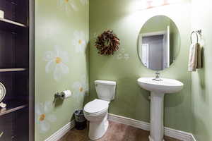 Bathroom featuring tile patterned floors, baseboards, and toilet