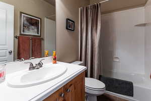 Bathroom featuring a shower with curtain, vanity, and toilet