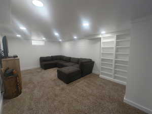 Carpeted living area featuring baseboards