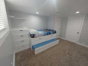 Bedroom featuring light carpet, recessed lighting, and a textured ceiling
