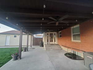 View of patio featuring fence, ceiling fan, and cooling unit