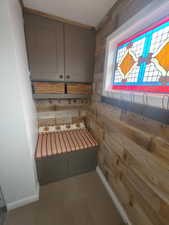 Mudroom featuring wooden walls and baseboards