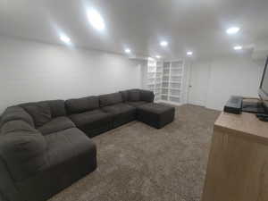 Living area with carpet floors, baseboards, and recessed lighting