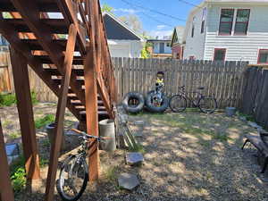 View of yard with a fenced backyard and stairs