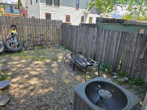 View of yard featuring fence and central AC unit