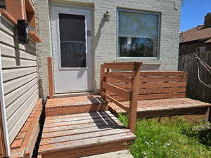 Entrance to property featuring fence and brick siding