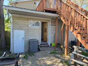 Property entrance featuring board and batten siding and cooling unit