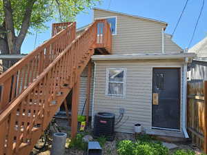 Back of property featuring stairs, central AC, a deck, and fence